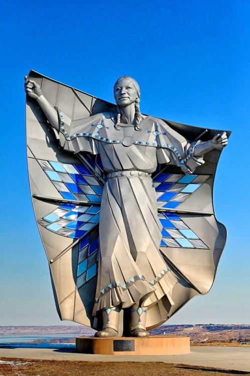 blondebrainpower:Dignity is a sculpture on a bluff overlooking the Missouri River near Chamberlain, South Dakota. The 50-foot high stainless steel statue by South Dakota artist laureate Dale Claude Lamphere depicts an Indigenous woman in Plains-style