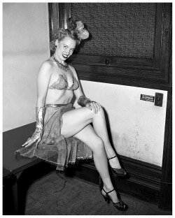 Vintage press photo dated from January of ‘52 features Ramona Durand posing in her dance costume, at police headquarters.. She had just been arrested for a performance in Queens, New York; on charges of “lewd and indecent exposure”..