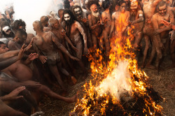 konstantinohatzisarros:Naga Sadhus, considered by many to be Holy people in India warm up after a Holy bath in the cold waters of Ganga river during Kumbh Mela festival in India. Naga Sadhus live a   life dedicated to Lord Shiva, the Hindu God. They
