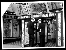 Press photo dated from the mid-50&rsquo;s features an unidentified Burlesque theatre on South Wabash Avenue in Chicago.. A pair of sailors check their wallets to see if they have enough cash to catch (yet) another viewing of Irving Klaw&rsquo;s 1954 film: