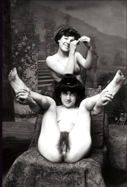 Ok not only do we have a potted palm, the striped chaise, paintings of potted palms, and these two lovely ladies, BUTI am pretty sure that the girl in the back is holding a Victorian condom that she’s miming putting on her pinky. Which would make this