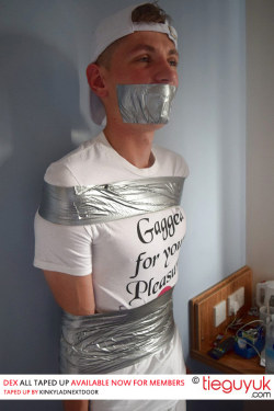 tieguyuk:  I love it when you can tell they’re grinning beneath the duct tape :-). Check out 18 year old Dex all taped up. Now online for members courtesy of kinkyladnextdoor. 