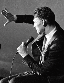 tomhazeldine:  Tom Hiddleston using his hand to block out one of the stage lights because he can’t see the person asking the question. 