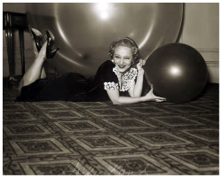 Vintage press photo dated from 1937, features showgirl Sally Rand posing in her Chicago hotel room with some of the balloons she uses in her famed “Bubble Dance”.. Sally hired an Ohio rubber company to develop a translucent balloon large enough, so
