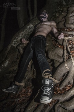 bound-indulgence: kinkbound:  Simple bondage pic but there’s something incredibly hot about this on multiple levels:  The roots of the tree the guy is tied to looking somewhat devious…. like tentacles or phallic shapes. His skater sneakers. The lighting.