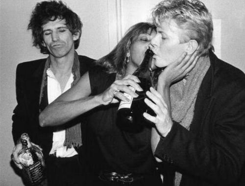 blondebrainpower:Tina Turner pouring champagne into David Bowie’s mouth, as Keith Richards looks on. 1982