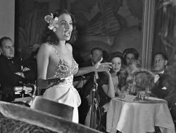 milkandheavysugar:  “Singer, Lena Horne, flower tucked behind her ear (perhaps in tribute of Billie Holiday who famously wore a gardenia in her hair)  performs at a lounge in the Savoy-Plaza Hotel in late 1942 in New York, New York.” To the right