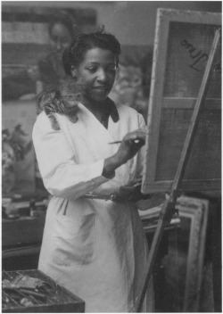 optimistfeminist:  theyorkist:  Loïs Mailou Jones painting in her Paris studio in 1937 or 1938, with kitten supervising from her shoulder  This is the kind of cat picture I’m here for 