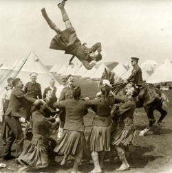 A group of soldiers with a cloth to throw one of them into the air during preparations for the battle at the front, England, 1915.