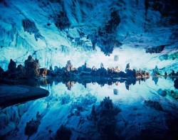 heartlesshippie:  bubbleant:  obliteratedheart:  Guangxi Zhuangzu region, China—Chandeliers and pillars of stone, their edges and shadows doubled in the glass-smooth surface of an underground pool, have awed visitors to the Reed Flute Cave for more