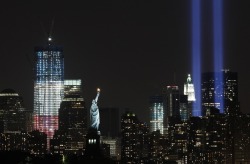thedailywhat:  Photo of the Day: The 88 searchlights of the Twin Towers’ Tribute in Light shine brightly while the half-built One World Trade Center, the lead building of the new World Trade Center complex, stands tall nearby, bathed in red, white,