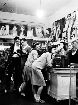 vintagegal:  Group of teenagers listening to 45 rpm. records as they shop for the latest hits at a record store. 1944 Photo by Nina Leen 