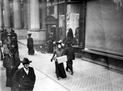  viα feuille-d-automne: Christmas shoppers, a woman holding a parcel and walking past a covered store window at Marshall Field’s department store on State Street, Dec. 1905, 