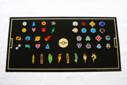 blazerdesigns:  The new revamped Elite Four Collection of my Pokemon badges. Still have to get it framed but this is essentially it: all Pokemon badges fitted with magnets that attach to a steel plate while allowing for future generation of badges to