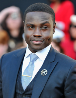 ayries:  roxanneritchi:  fyeahlilbitoeverything | rodrikharlaw:   [Image Description: Photograph of Dayo Okeniyi, presumably at a red carpet event for The Hunger Games, in which he played Thresh. He is wearing a blue three-piece suit with a pinstripe