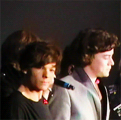  ‘Grenade’ in Cardiff [x] Louis pointing out a ‘Larry Stylinson threesome’ poster to Harry. 