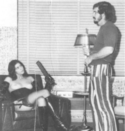 What&rsquo;s interesting about this particular pic is that, the man&rsquo;s vanilla clothing and hair style strongly fixes in him time (1970s), the woman&rsquo;s hairstyle and fetish wear (corset, stockings, garter belt, boots, opera gloves) dislocate