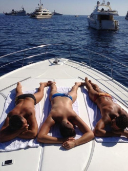 Friends tanning together on a boat