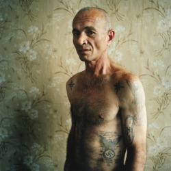 letsgoeast:  A man with a swastika tattoo (didn’t reveal his crime). Men’s prison, Ukraine, 2008 - Ph.  Michal Chelbin Read more: http://lightbox.time.com/2012/10/01/sailboats-and-swans-the-prisons-of-russia-and-ukraine/#ixzz284zzZlZR 