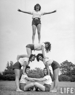 bygoneamericana:  Group of teenage girls from Hoover High School doing a pyramid in gymnastics class. San Diego, 1946. By Martha Holmes   