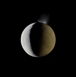 timelightbox:  Enceladus vents water into space from its south polar region. The moon is lit by the Sun on the left, and backlit by the vast reflecting surface of its parent planet to the right. Icy crystals from these plumes are likely the source of