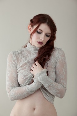 Gorgeous redhead in a lacy, see-through top.  Someone should cheer her up.