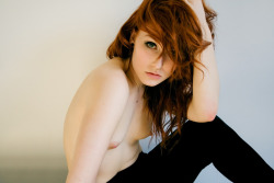 Gorgeous topless redhead in black stretchy pants.