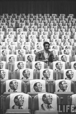 sinuses:  Bill Cosby sitting in empty auditorium filled with copies of his likeness on each seat, Las Vegas, 1968. Photo: Michael Rougier 